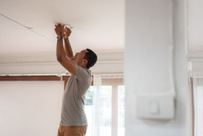 African American Man changing light bulb